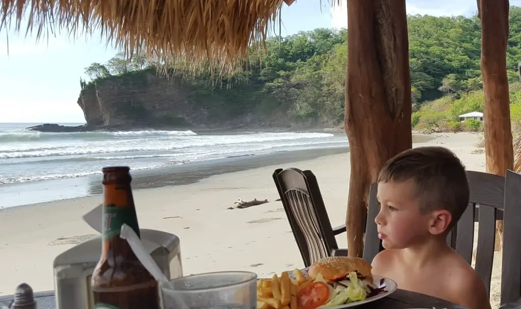 Eli at a table overlooking playa el coco beach in nicaragua