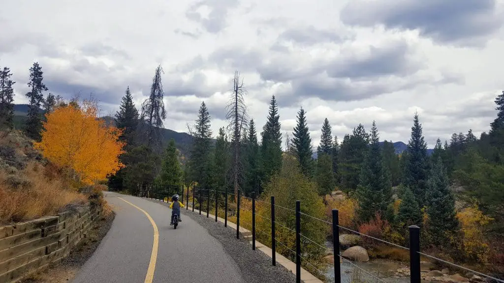 boy riding his bike on the snake river rec path in Keystone, CO