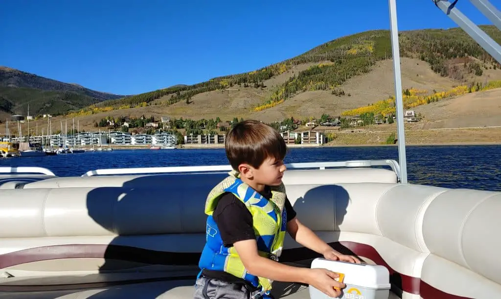boy on a pontoon boat on lake dillon in the fall