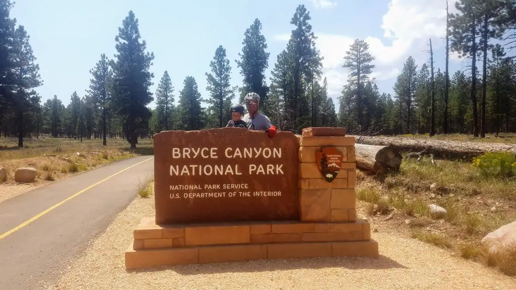 Bryce Canyon National Park Sign with child and adult standing behind.