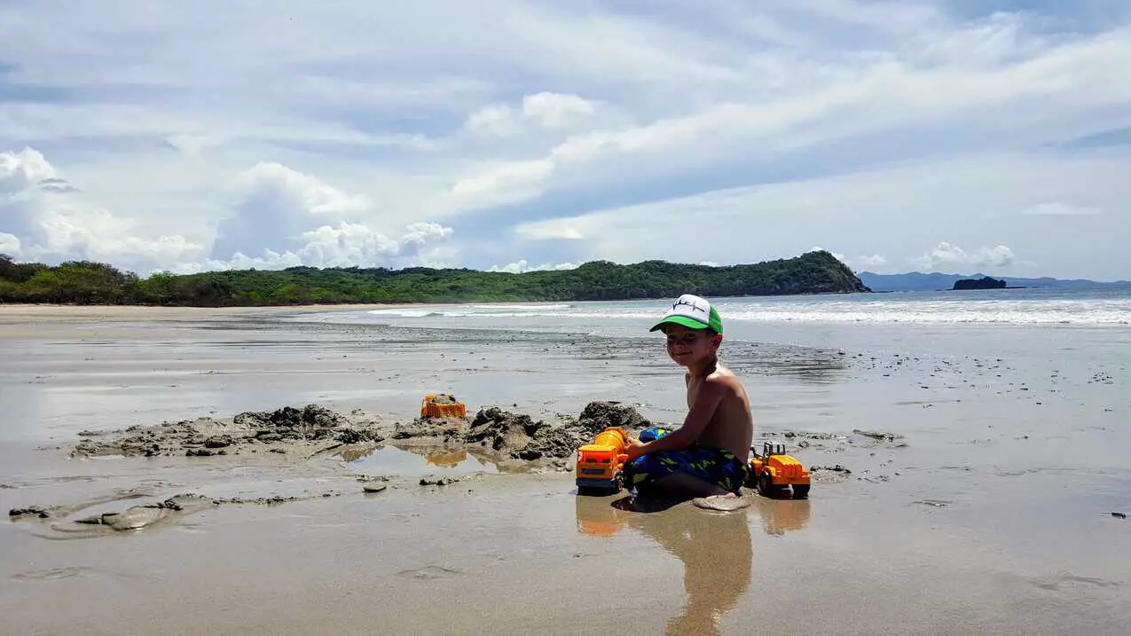 Eli playing with toy trucks on Playa La Flor beach