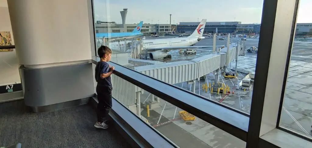 Boy standing at the window at the airport