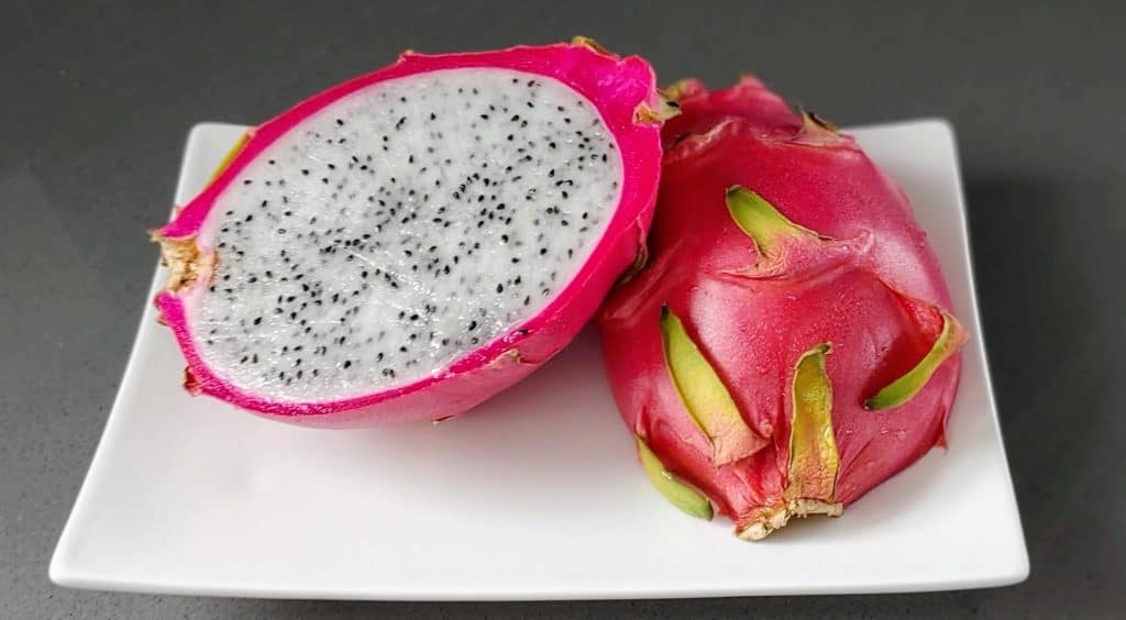 Dragon Fruit cut open showing the white flesh and seeds inside. Dragon Fruit is one of the fruits grown in Hawaii.