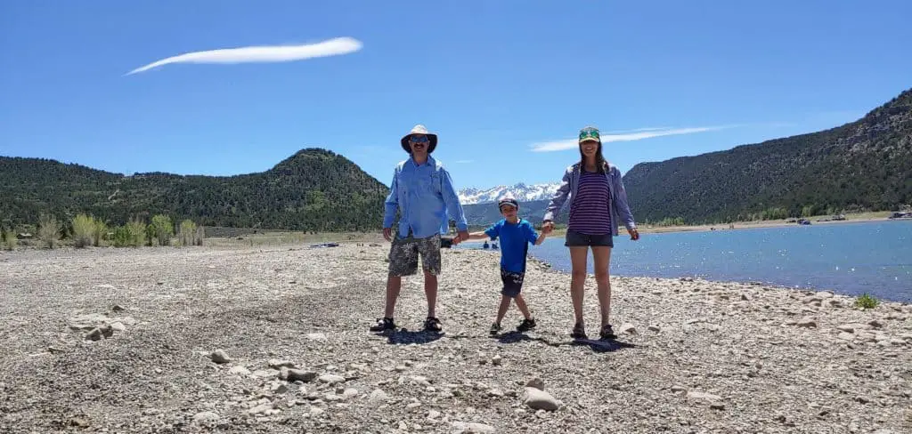 family standing in front of the San Juan mountains at Ridgeway Reservoir