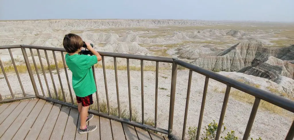 Young boy looking through binoculars at a viewpoint in Badlands National Park