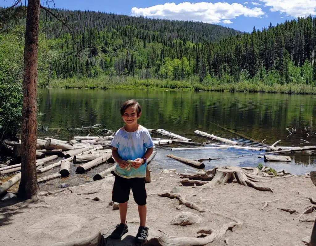 Boy standing in front of Rainbow Lake in Frisco, Colorado