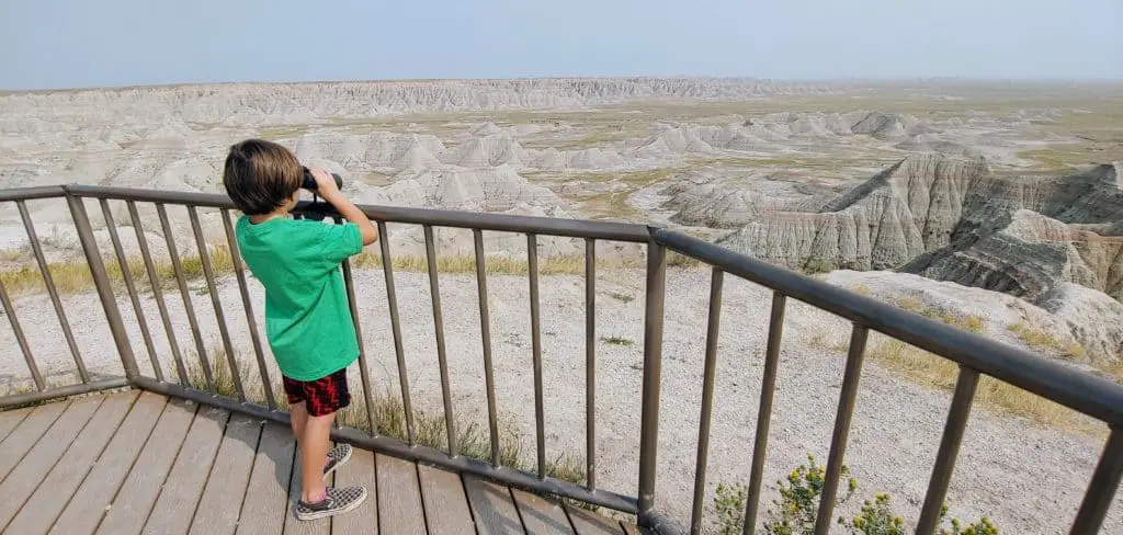 boy looking through binoculars at a viewpoint in Badlands National Park
