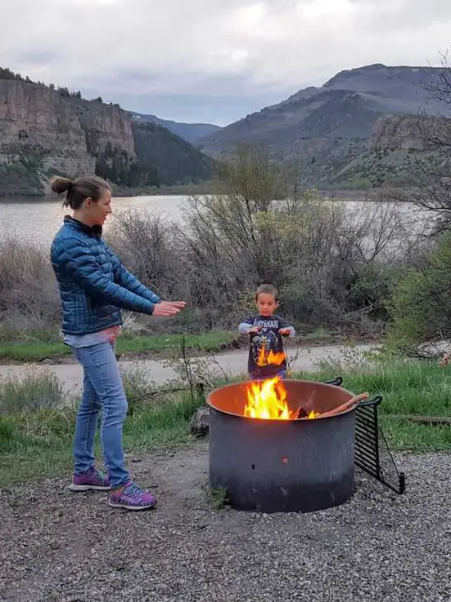 Mom and son around a campfire at a forest service campground