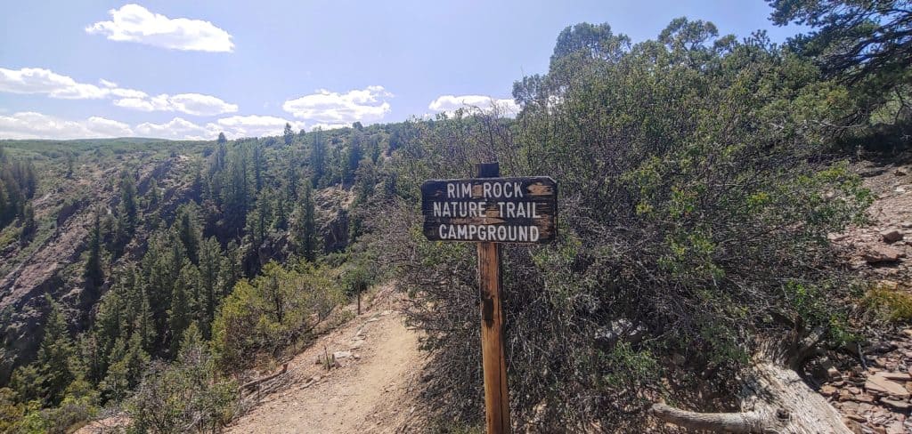 hiking trail sign and hiking trail at Black Canyon of the Gunnison National Park in Colorado