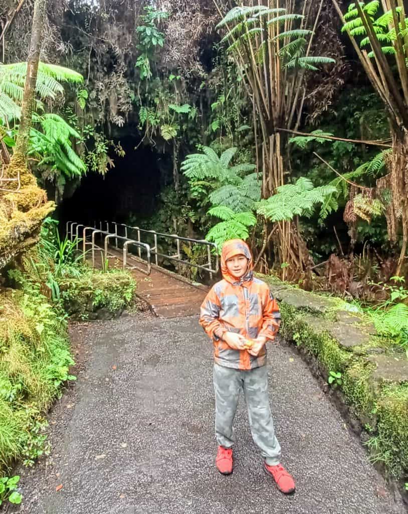 boy standing in front of the Thurston Lava Tube in Volcano National Park Hawaii