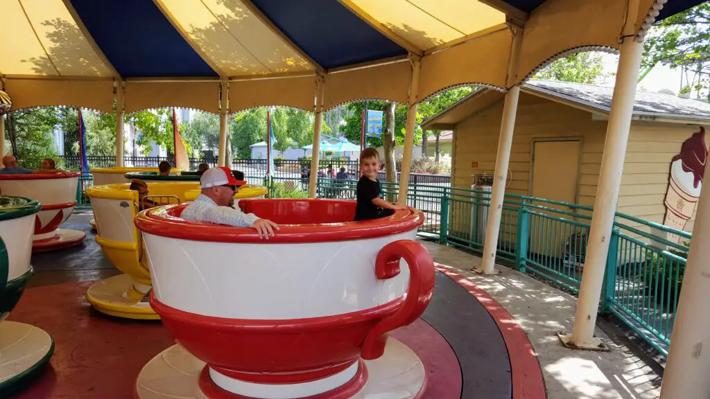 father and son on a teacup ride at Elitch Gardens one of the best things to do in Denver with kids
