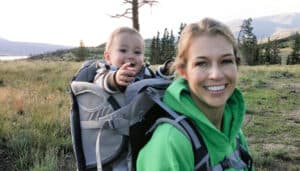 Toddler on mom's back in a backpack carrier