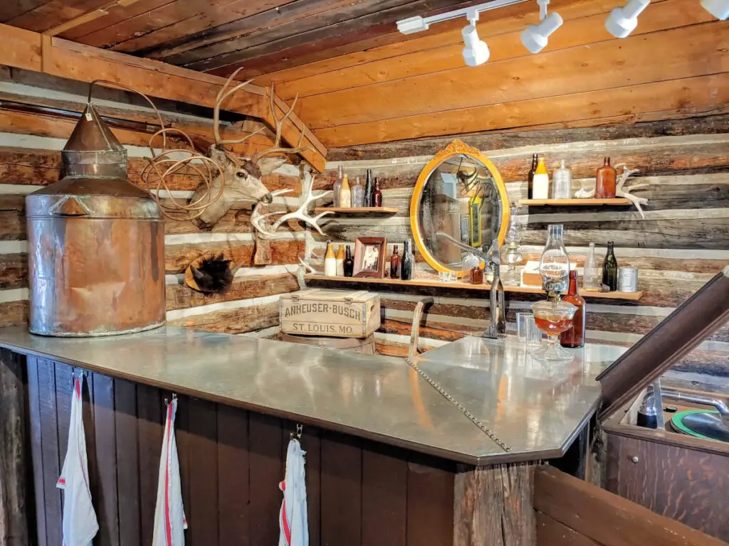 Old bar with antique bottles of booze in a restored log cabin in the Frisco Historic Park