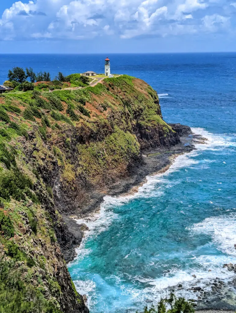 Kilauea Lighthouse on the end of a rocky point surrounded by the bright blue ocean, island of Kauai