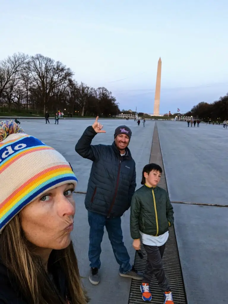 Parents and child standing in front of the Washington Memorial in Washington DC